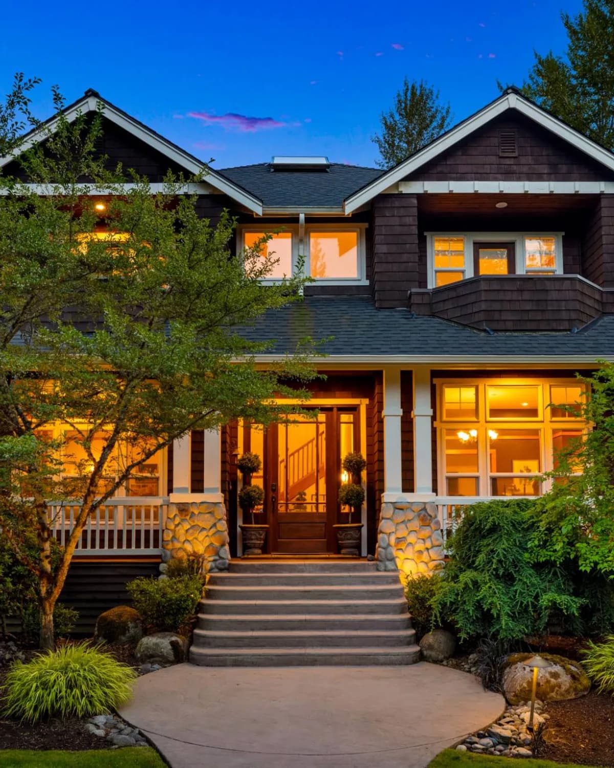 Craftsman home at twilight with a lit front entry
